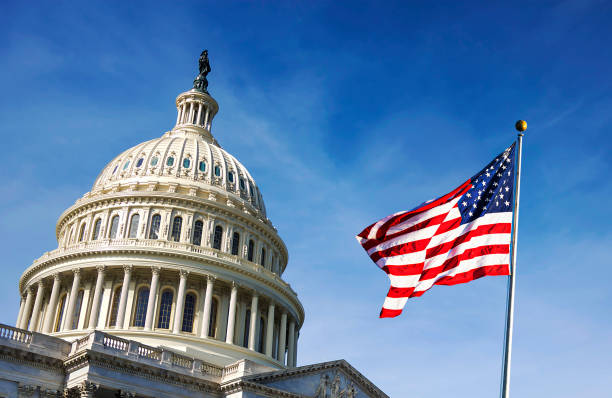 American flag waving with the Capitol Hill in the background American flag waving with the Capitol Hill in the background